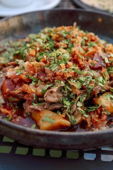 a bowl of food with meat and vegetables on top
