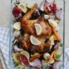 grilled whole chicken with vegetables and fruits in glass bowl