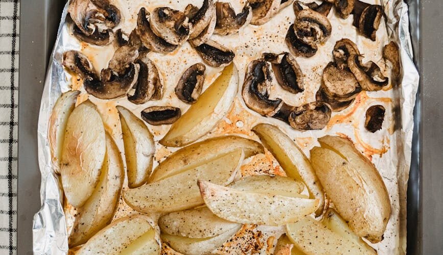 roasted potato wedges and mushrooms on the tray